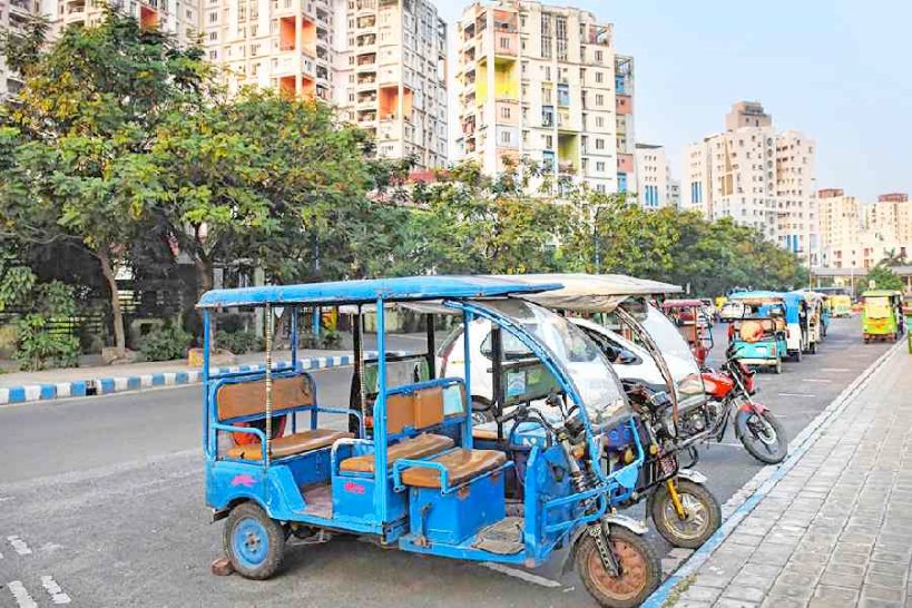 Electric autorickshaws parked along a city street